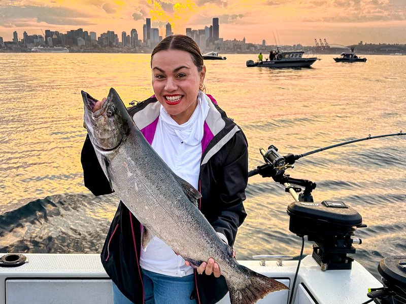 Jessica holding a king salmon on a boat in Seattle